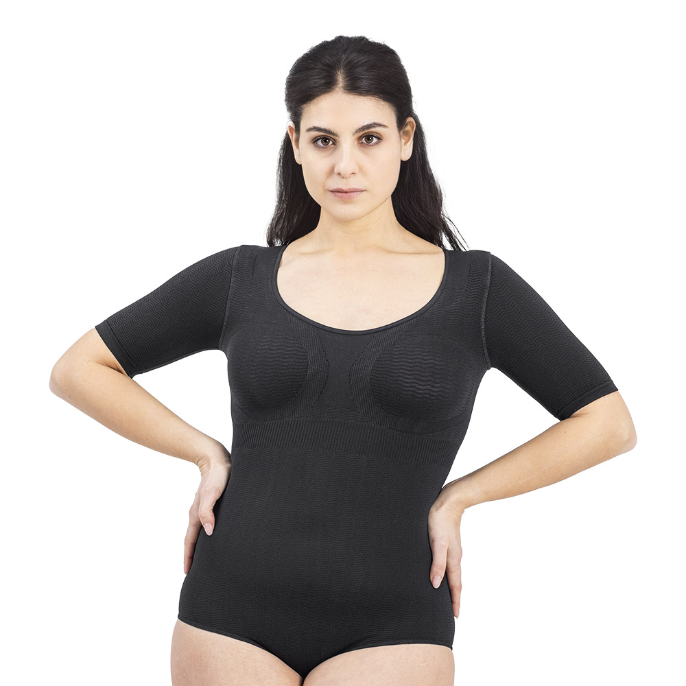 A woman wearing the Silver Wave Body Skin Pro bodysuit with elbow-length sleeves in Nero